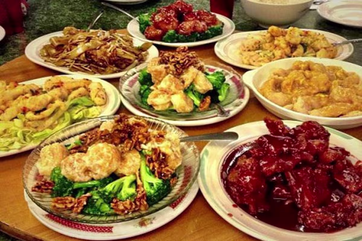 A large round table covered with shared Chinese dishes at Golden Harvest